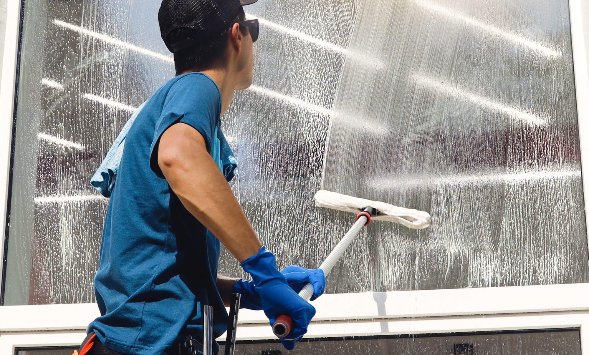 A professional window cleaner squeegeeing glass at a Spokane property